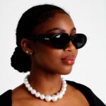 Black Female Model wearing Nature Sunglasses and a black designer dress with pearls, luxurious rectangle sunglasses by AKA SAVRAN