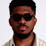 Black male Model wearing Equilibre Sunglasses, luxurious round sunglasses by AKA SAVRAN