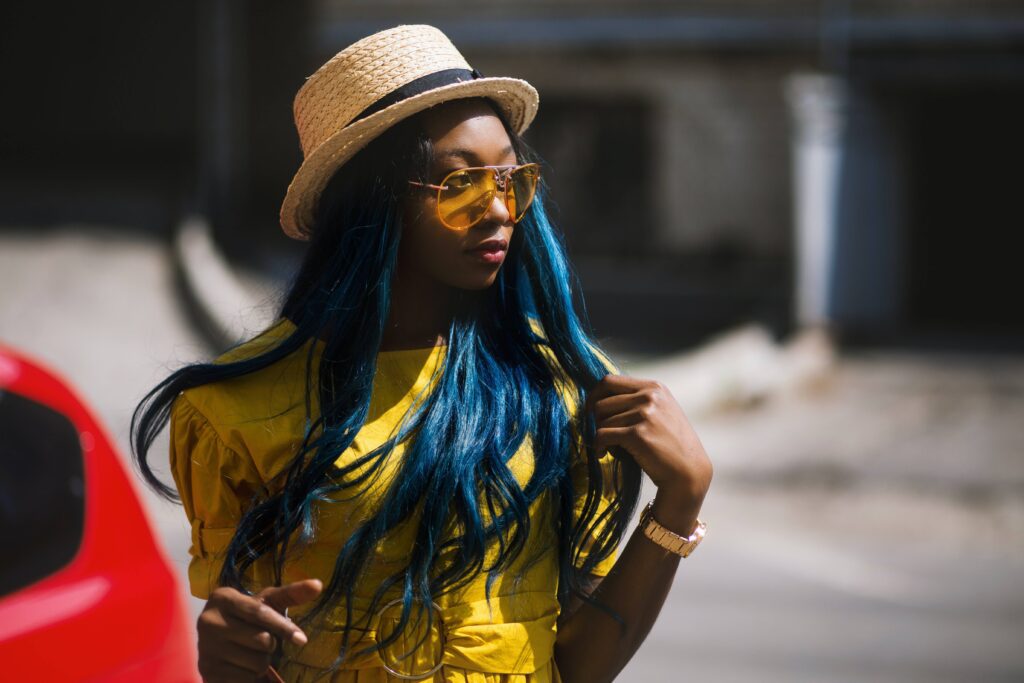 Black girl with blue hair and with sunglasses and coloured lenses
