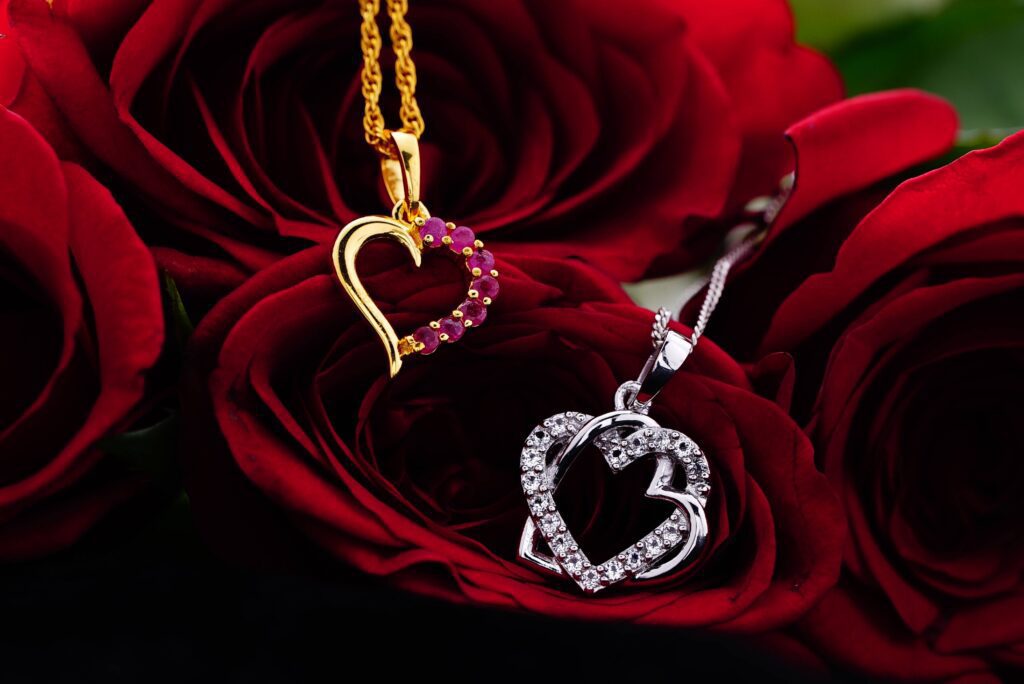 romantic golden and platinum necklaces placed on red roses