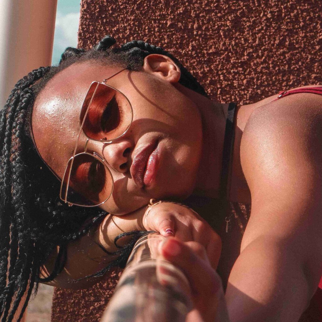 black woman wearing luxury sunglasses for women with coloured lenses