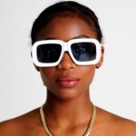 Black Female model wearing Luxury Oversized sunglasses, Supreme by luxury eyewear brand AKA SAVRAN, similar to Loewe Paula's Ibiza Dive in Mask Sunglasses
