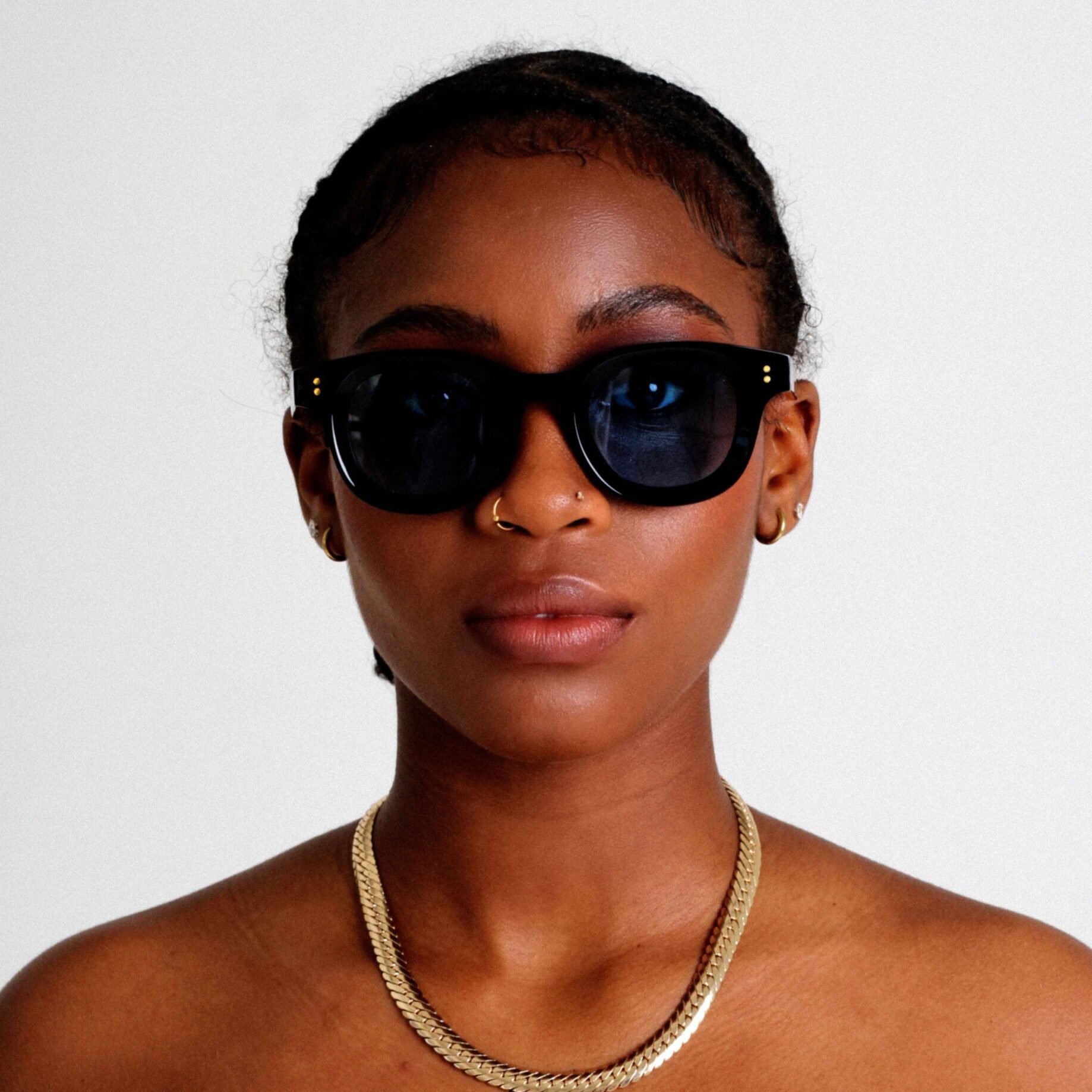 Schwarzes weibliches Model trägt KOKO BLEU, luxuriöse runde Sonnenbrille von KOKO SUNGLASSES COLLECTION von AKA SAVRAN