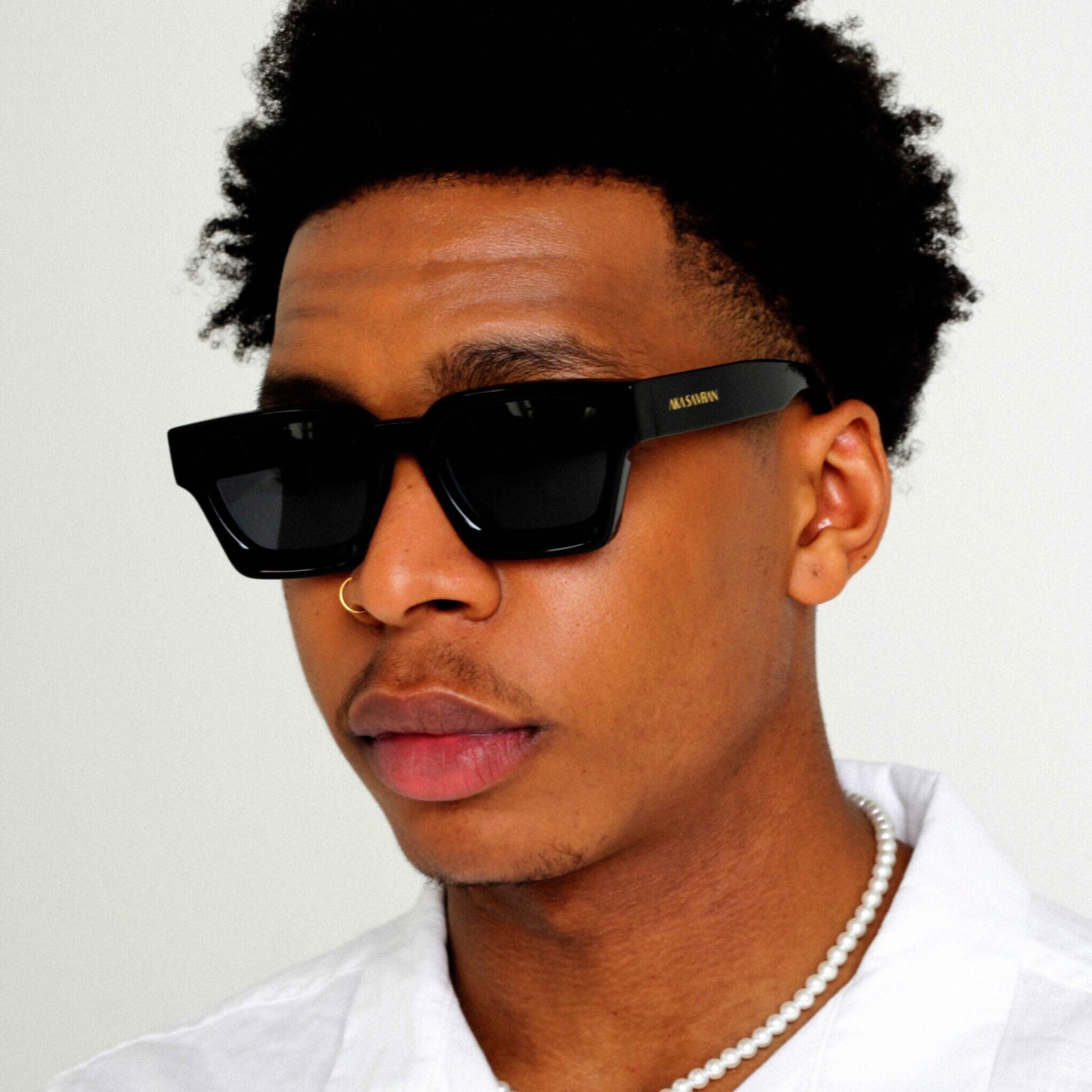Modelo masculino negro con Rebel, lujosas gafas de sol cuadradas de AKA SAVRAN, inspiradas en Virgil Abloh