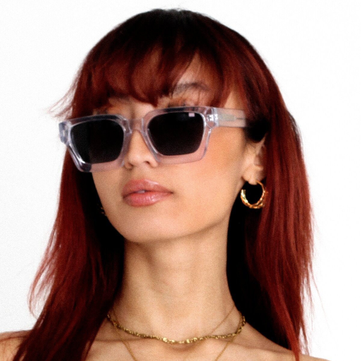 Asiatisches weibliches Model trägt die Rebel Transparent Sonnenbrille, eine luxuriöse quadratische Brille von AKA SAVRAN, die von Virgil Abloh inspiriert und aus Acetat gefertigt wurde.